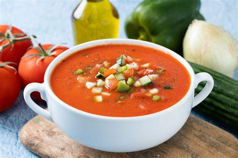 Gazpacho en un bol con diversas guarniciones alrededor