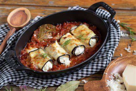 Rollitos de berenjena recién horneados con salsa de tomate y hierbas