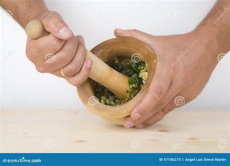 Mortero con ajo y perejil machacándose