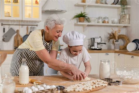Abuela enseñando a sus nietos a cocinar recetas tradicionales en la cocina