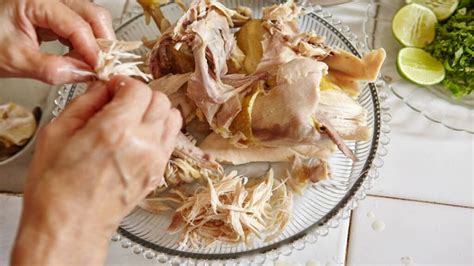 Manos desmenuzando pollo cocido