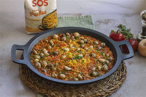 Paella de caracoles servida en mesa