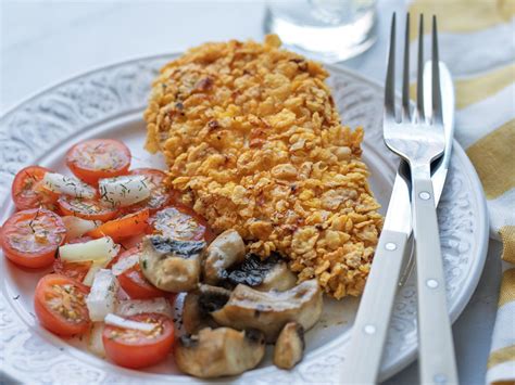 Plato de pechuga de pollo empanada con harina de maíz acompañada de ensalada