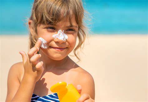 Niños aplicando protector solar en la playa