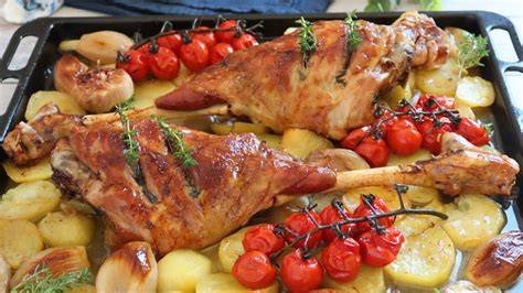 Pata de cordero asándose en el horno con verduras