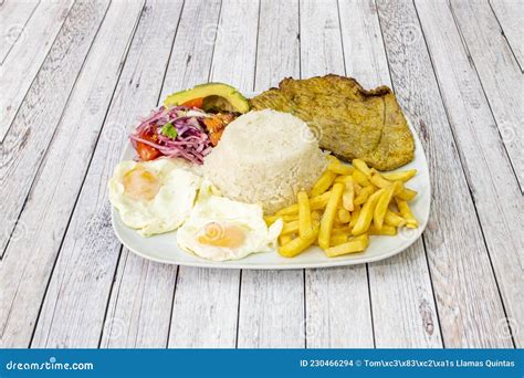 Plato de churrasco con patatas fritas y ensalada