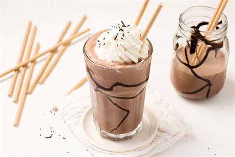 Vaso alto con batido de chocolate decorado con nata y sirope