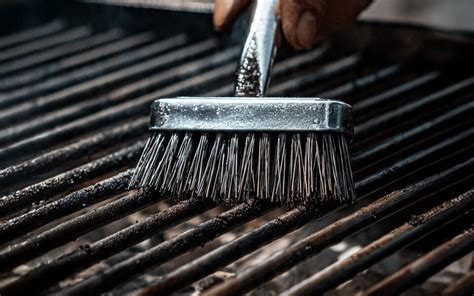 Persona limpiando una barbacoa de obra