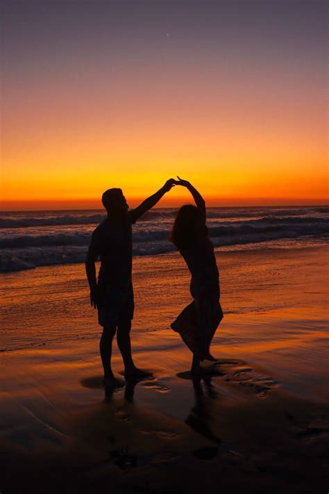 Pareja bailando un ritmo latino en la playa al atardecer