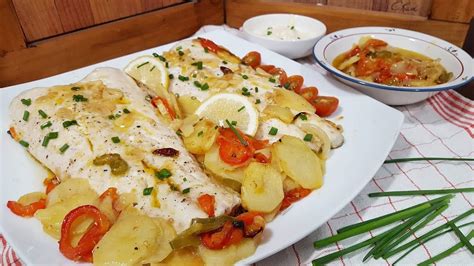 Filetes de merluza en una bandeja de horno con tomates cherry
