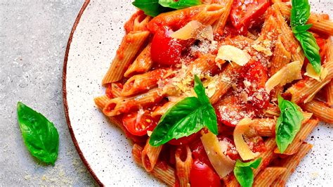 Pasta con salsa pomodoro y hojas de albahaca fresca