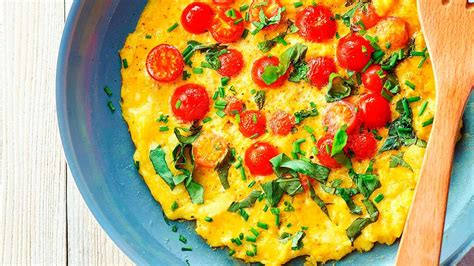 Tortilla de patata decorada con hierbas frescas y tomates cherry
