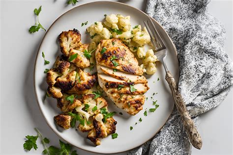 Plato de coliflor salteada con pollo y salsa de soja, decorado con ajo tierno