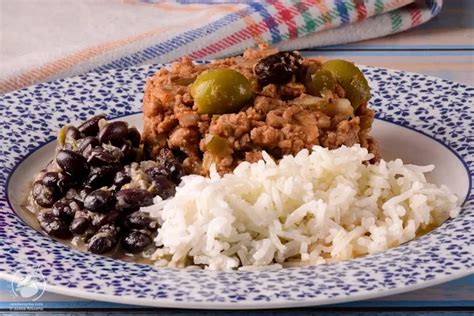 Plato completo de arroz blanco con picadillo cubano, frijoles negros y tostones
