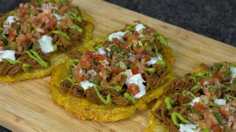 Plato de patacones con carne desmechada y aguacate