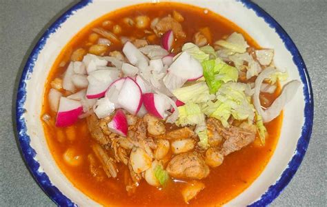 Plato de pozole rojo con sus acompañamientos