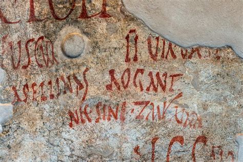Grafitis antiguos en una pared histórica con mensajes diversos
