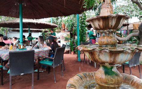 Exterior del Restaurante El Cordero con el cordero esculpido en árboles