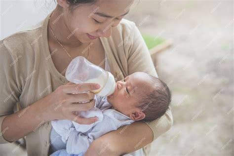 Bebé siendo alimentado con biberón por su madre
