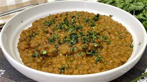 Mesa con ingredientes para lentejas al curry: lentejas, cebolla, ajo, especias, tomate y leche de coco