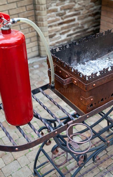 Imagen de un extintor de incendios junto a una barbacoa
