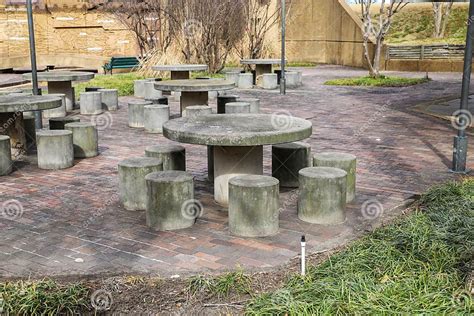 Área de picnic con mesas de piedra y árboles