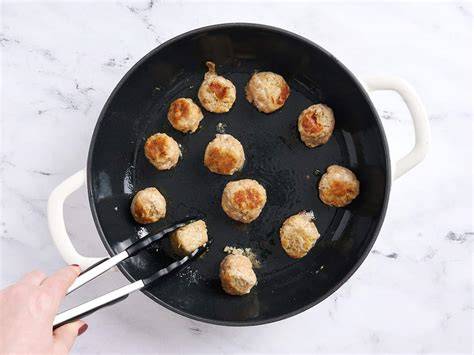 Albóndigas dorándose en sartén