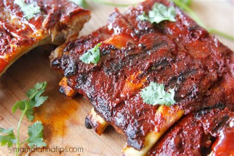 Costillas de cerdo al achiote listas para servir con decoración de naranja y perejil