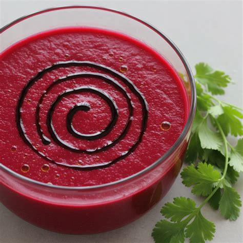 Gazpacho de remolacha en un cuenco con una ramita de albahaca