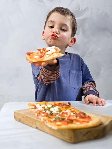 Niño comiendo una mini pizza de berenjena