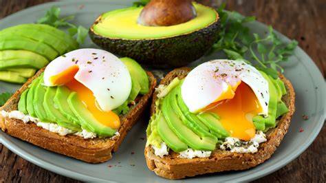 Plato con huevos cocidos, aguacate y tostadas, representando un desayuno saludable