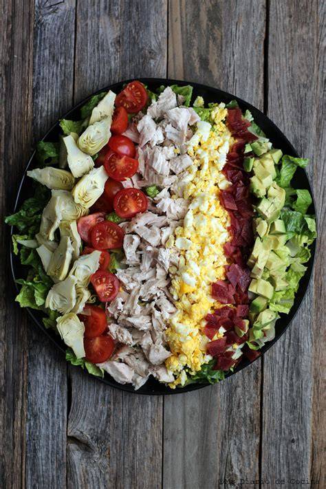 Presentación clásica de la ensalada Cobb con ingredientes en filas
