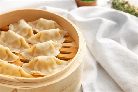 Plato de dumplings chinos recién hechos en una vaporera de bambú, listos para servir.
