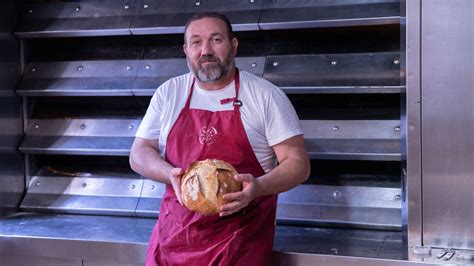 Federico Jiménez exhibiendo su pan premiado en la panadería
