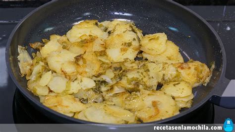 Patatas y cebolla friéndose en una sartén