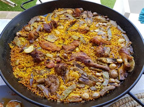 Paella valenciana tradicional cocinada a leña