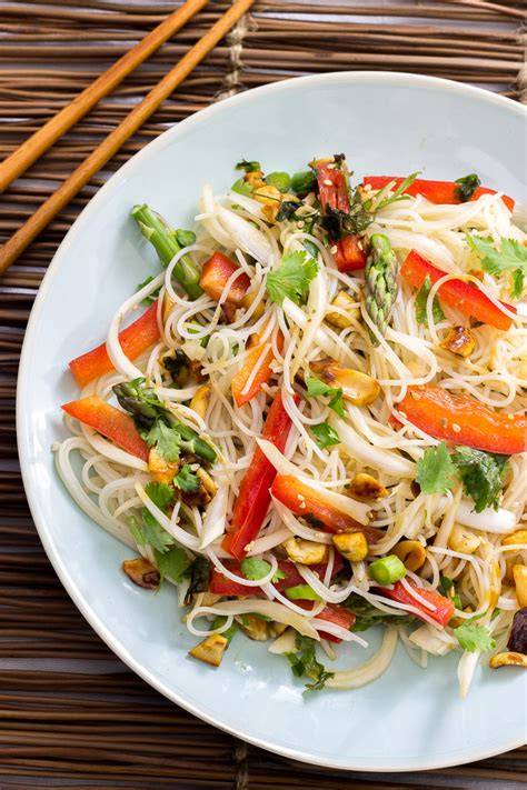 Ensalada oriental de fideos de arroz con verduras frescas y cacahuetes