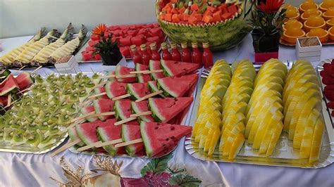 Mesa con ensaladas frescas, aperitivos y brochetas de fruta