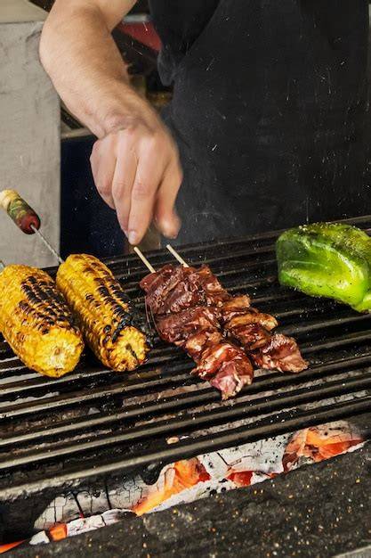 Chef experimentado volteando carne en la parrilla