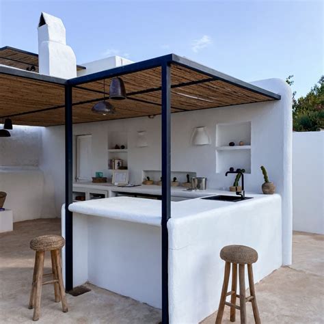 Cocina exterior de obra con cortinas de ikat para almacenaje