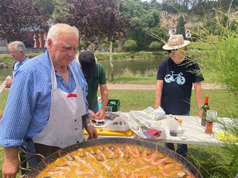Persona cocinando paella al aire libre con un cortavientos
