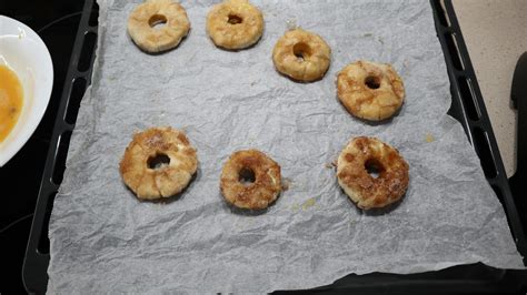 Bandeja de rosquillas de hojaldre con manzana y canela dorándose en el horno