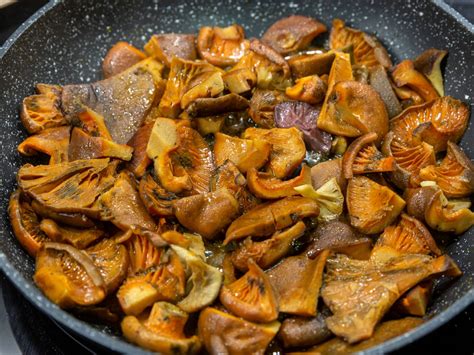 Níscalos cocinándose en una sartén con especias