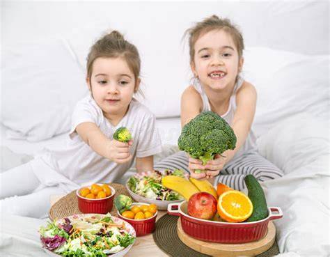 Niños comiendo frutas y verduras