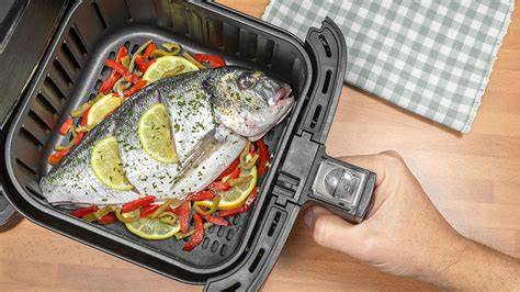 Mujer cocinando pescado en freidora de aire