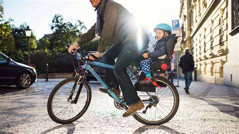 Bicicleta con silla trasera y niño con casco