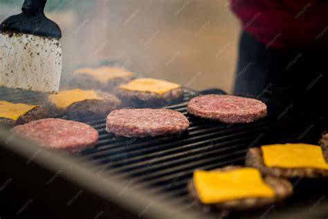 Hamburguesas en la parrilla con queso fundiéndose