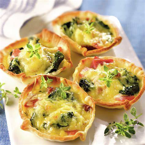 Tartaletas de espinacas y jamón en una bandeja de horno