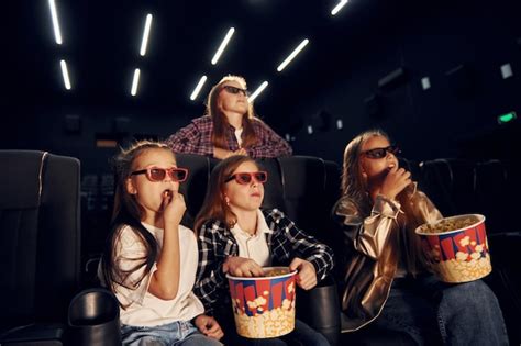 Niños comiendo palomitas de maíz en el cine