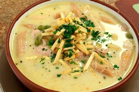 Plato de sopa de maní boliviana servida con papas fritas